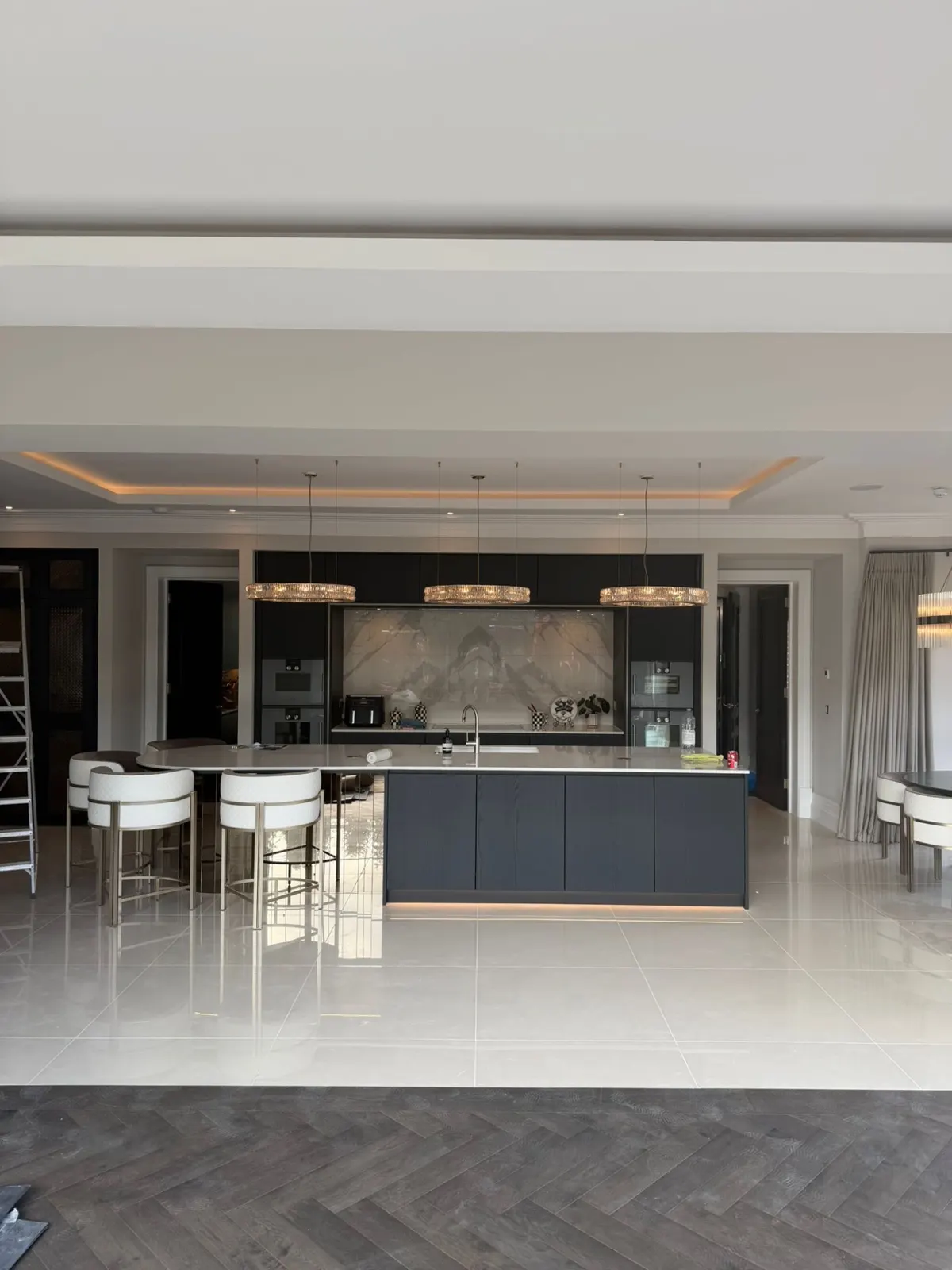 Open-plan kitchen with navy island and herringbone floor