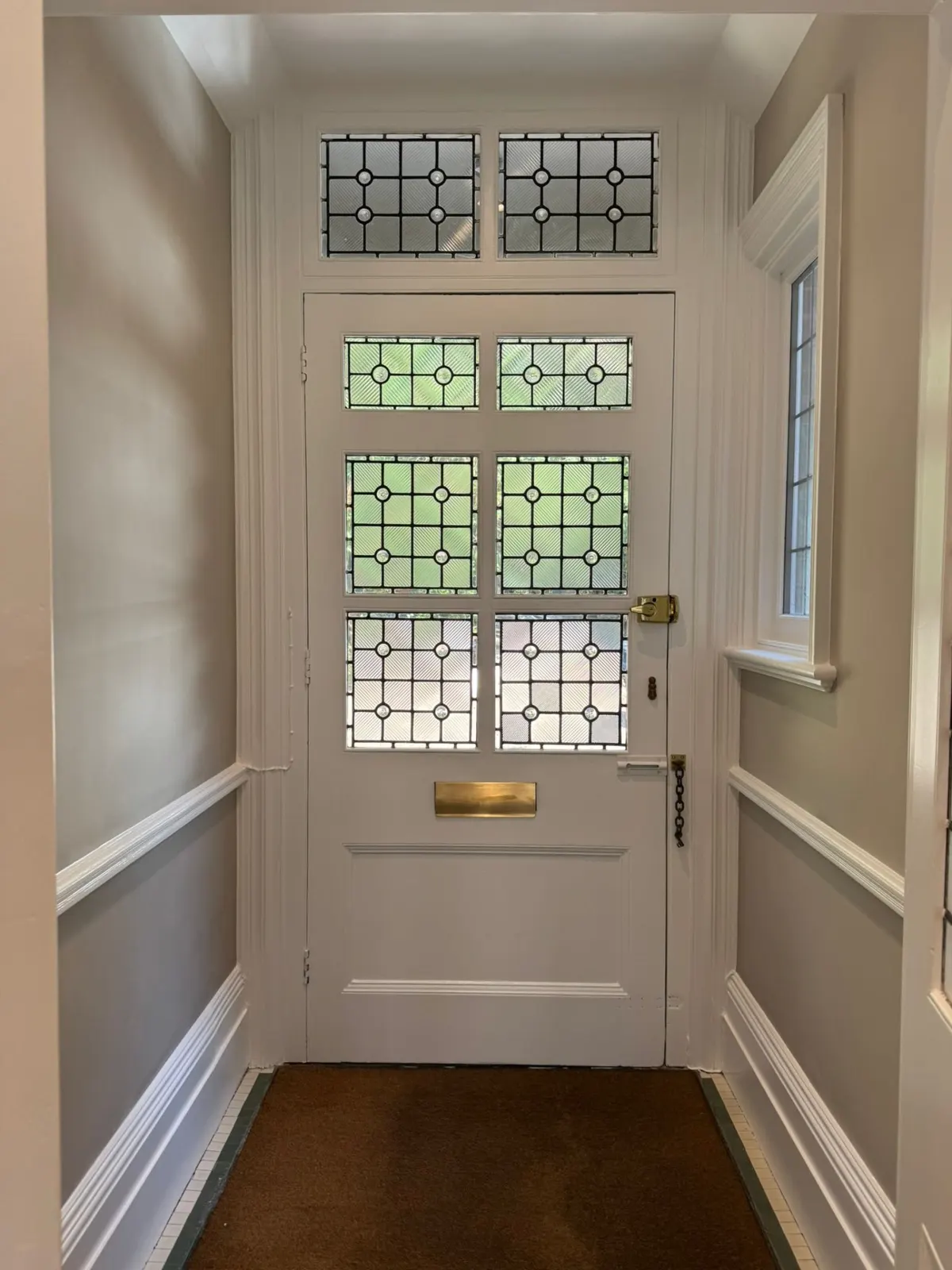 Finished entrance hall with restored leaded-glass door