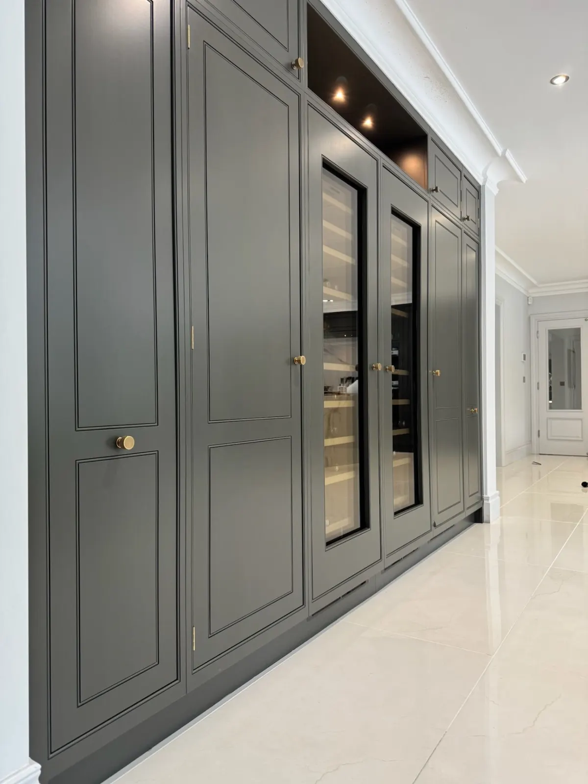 Dark grey cabinetry with glazed wine storage