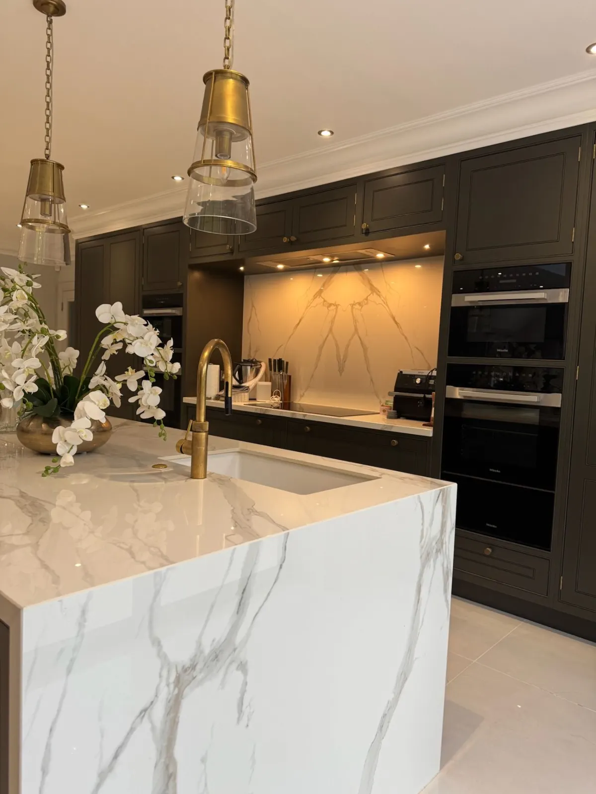 Dark sprayed kitchen cabinetry with marble island by Underwood Decor